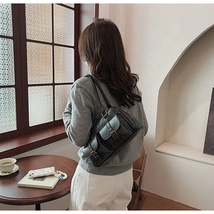 Retro black leather underarm bag with double buckle pockets shown on a model