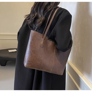 Close-up of vintage brown tote bag with retro leather texture and long shoulder straps