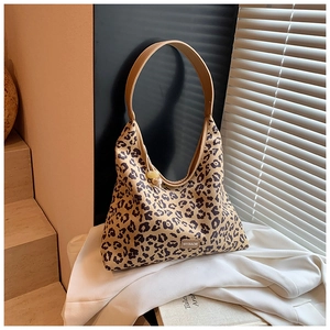 Detail of leopard print hobo bag showing thick canvas texture and brown leather strap