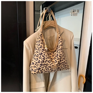 Detail of leopard print tote bag featuring canvas texture and stylish ball charm