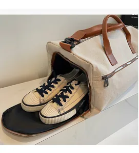 Detail of travel canvas bag showing separate shoe compartment with storage function