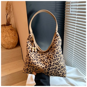 Detailed close-up of leopard print hobo bag with marble bead charms and smooth strap