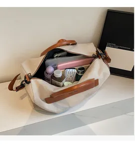 Spacious interior of canvas travel bag holding a laptop, tablet, and essentials