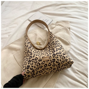 Detail of leopard print hobo bag featuring leather strap and beaded pearl zipper charm