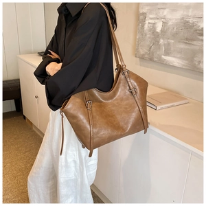 Detail view of the vintage brown tote bag showing adjustable straps and matte texture