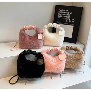 Detail view of stylish plush handbags in five colors with faux leather handles and straps