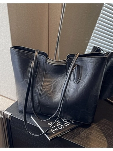 Classic black leather tote bag with zip closure and elegant shoulder straps for women