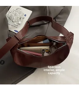 Interior view of large capacity dark brown crossbody bag showing spacious compartments