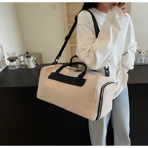 Detail of canvas travel bag with black contrast straps and side zipper compartment