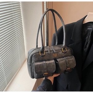 Close-up of vintage grey underarm bag with double front pockets and retro leather texture