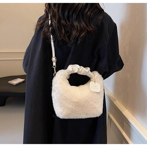 Detailed view of white fluffy plush handbag with scrunchie handle and gold buckle detail