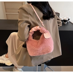Detail of pink faux fur handbag with leather handle and adjustable shoulder strap