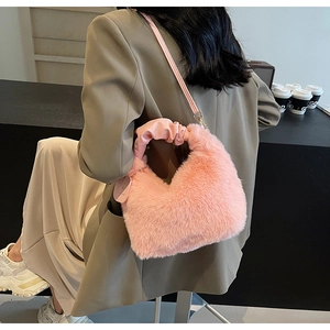 Close-up of pink faux fur handbag with ruched handle and shoulder strap in lifestyle setting