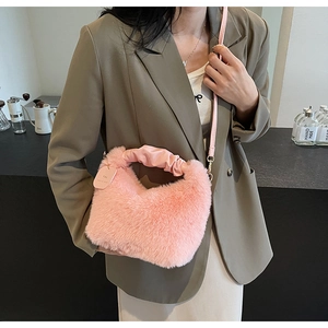 Close-up of pink faux fur crossbody bag with ruched leather handle and long shoulder strap