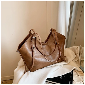 Detail showing vintage brown leather tote bag with silver buckle and adjustable strap