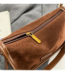 Détail du zip doré et de la texture en daim marron sur ce sac bandoulière vintage