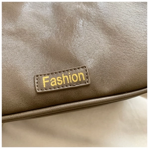 Detail shot of brown Boston bag showing premium leather texture and Fashion logo tag