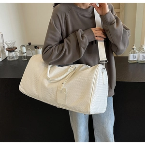 Dettaglio della trama intrecciata bianca di una borsa da viaggio con tag NOCO