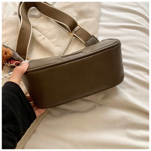 Detail of Boston pillow bag in khaki brown with striped strap and cute bear charm