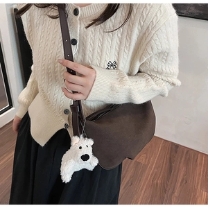 Detail of dark brown frosted crossbody bag with a cute white plush bear pendant decor