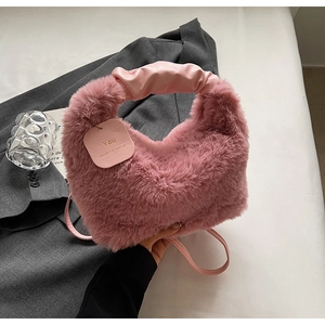Detailed shot of pink faux fur crossbody bag with leather scrunchie handle and tag