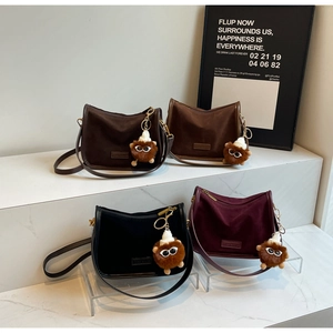 Détail de quatre sacs à bandoulière rétro colorés avec de mignons charms en peluche