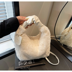 Detail of plush faux fur handbag with PU leather handle and decorative square tag