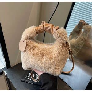 Detail view of plush faux fur handbag with ruched leather handle and detachable strap
