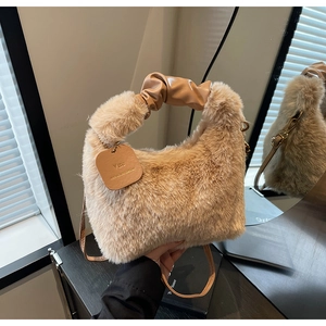 Detail of plush khaki faux fur handbag with stylish pleated leather handle and gold chain tag