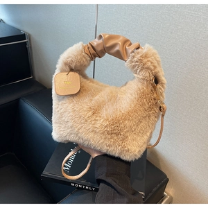Detail of soft faux fur handbag with ruched leather handle and small 'You' charm