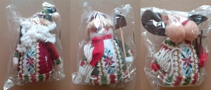 Close-up of knitted Christmas plush dolls in packaging including Santa and Snowman