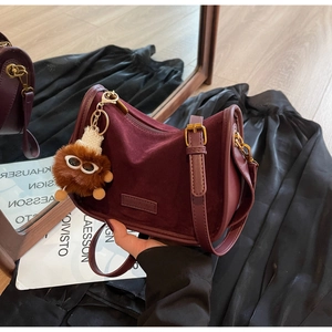 Détail du sac bandoulière vintage en daim bordeaux avec fermeture éclair dorée