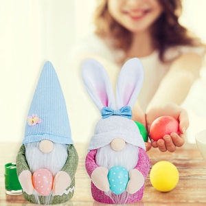 Détail de deux gnomes de Pâques avec oreilles de lapin tenant des œufs sur bois naturel