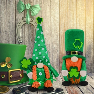St. Patrick's Day gnome dolls with green hats and orange beards on wooden background
