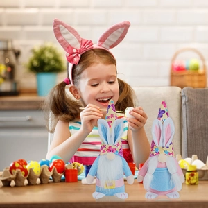 Close-up of Easter gnomes with rabbit ears and floral hats on a festive table