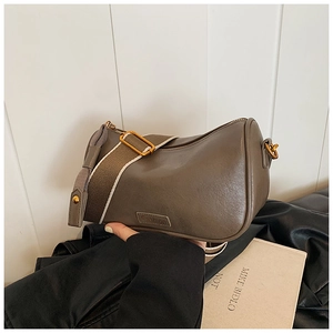 Detail of dark gray Boston bag with Fashion label and adjustable fabric shoulder strap