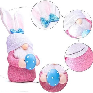 Gnome de Pâques avec oreilles de lapin et œuf bleu à pois sur fond blanc