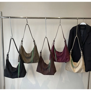 Détail de sacs seaux hobo en cinq couleurs avec des fermetures éclair tressées vert néon