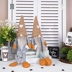 Detail of coffee gnomes sitting on books with knitted hats and white heart patches