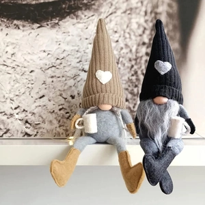 Detail of two Nordic coffee gnomes with knitted hats and heart patches on a shelf