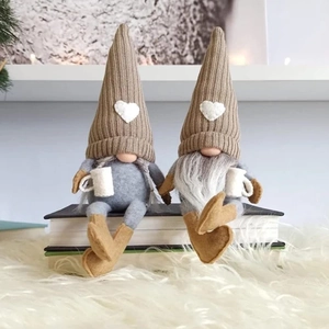 Close-up of two coffee-themed gnomes with knitted hats and cups on a plush white rug