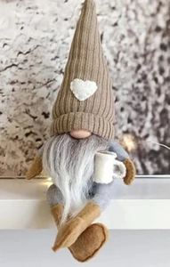 Close-up of Nordic Christmas gnome plush featuring heart pattern and small coffee cup detail