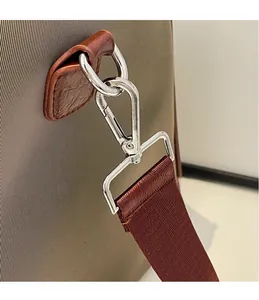 Detailed close-up of sturdy silver metal hardware hook on a durable fabric travel bag