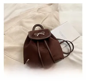 Detail eines dunkelbraunen Wildleder-Mini-Rucksacks mit silberner Schleife und Kordelzug