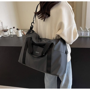 Dettaglio della borsa da viaggio grande in nylon antracite con logo NOCO e tracolla regolabile