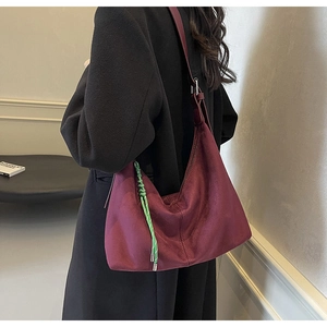 Détail du cabas bordeaux en daim avec boucle argentée et pendentif en corde tressée