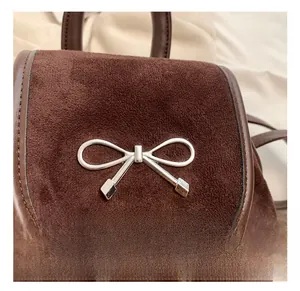Nahaufnahme der braunen Wildledertasche mit einer polierten silbernen Schleife
