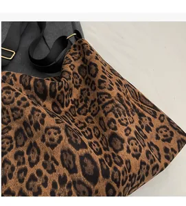 Detail der weichen Leopardenmuster-Stoffstruktur und schwarzem Gurt mit Metallschließe