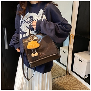 Brown leather backpack with ibm logo and cute yellow cloud pendant on the side