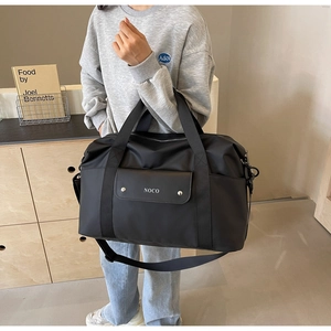 Dettaglio della borsa da viaggio nera impermeabile con tasca frontale e logo NOCO
